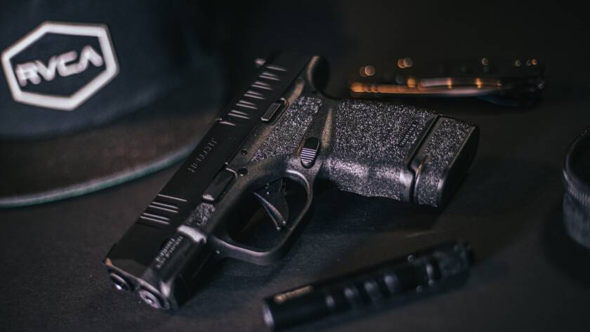 black semi automatic pistol beside black tube